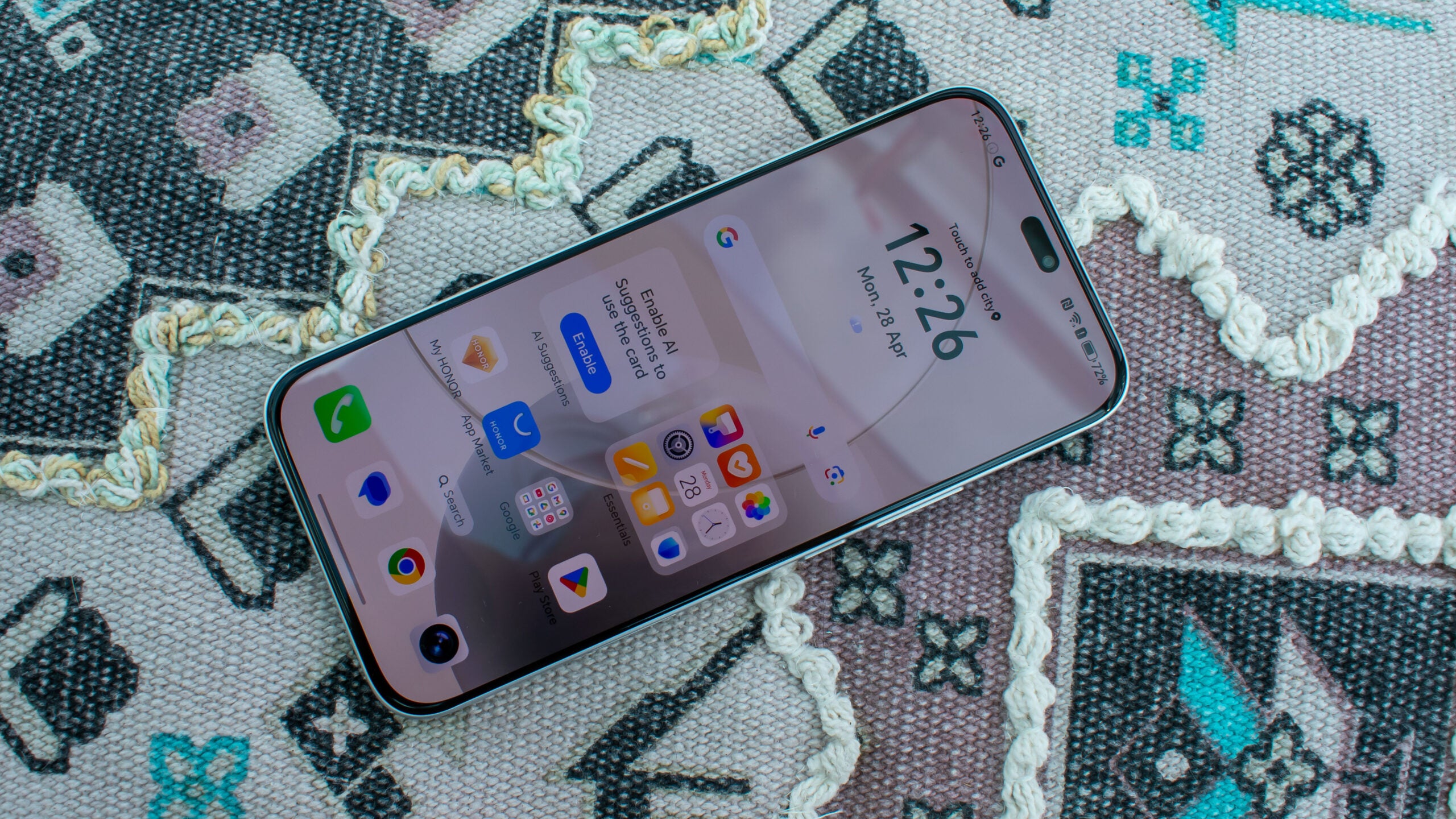 Honor 400 Lite лежит экраном вверх на узорчатой подушке