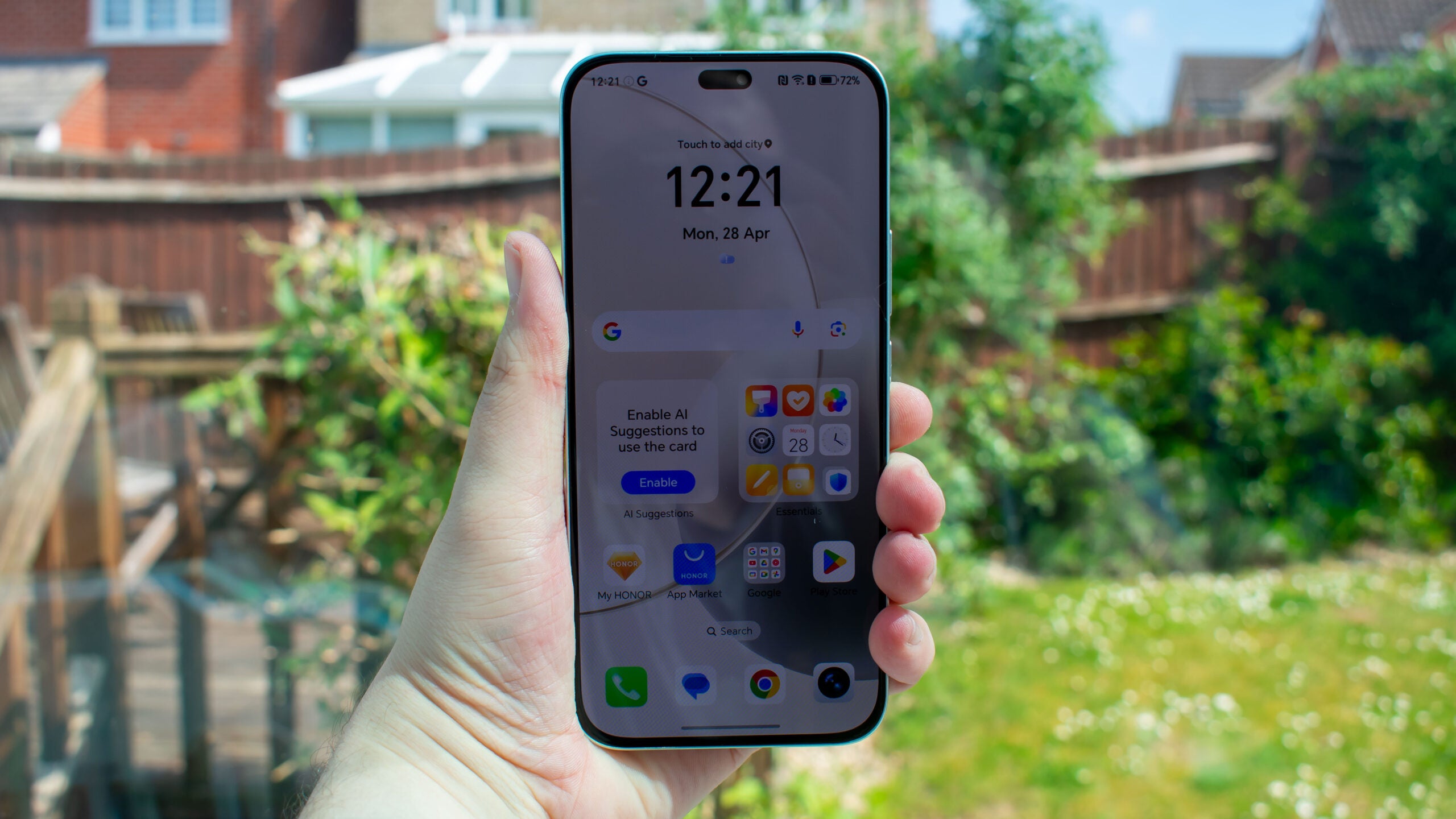 Honor 400 Lite в руке перед окном, экран включен