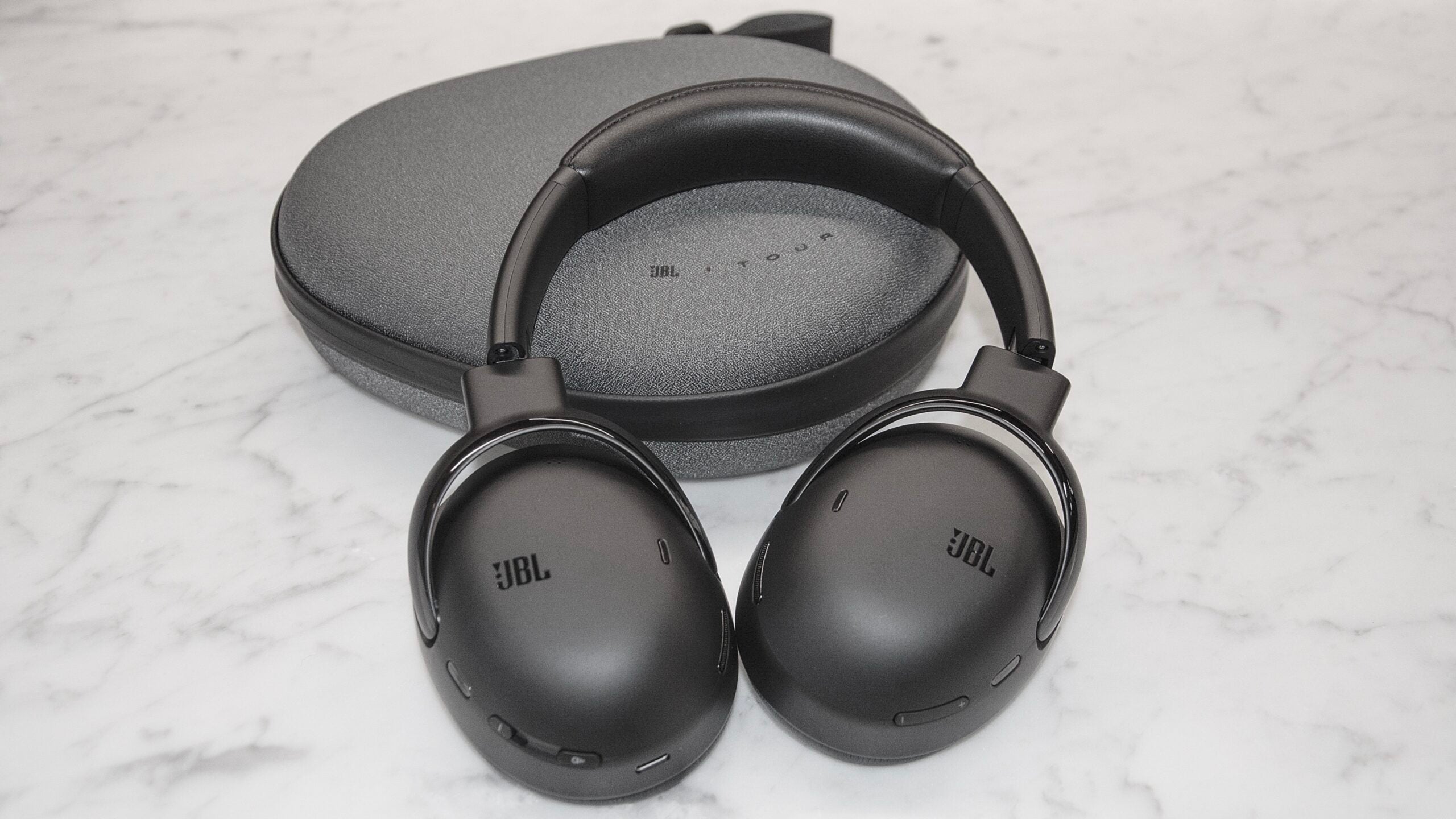 The JBL Tour ONE M3 propped upp on the case