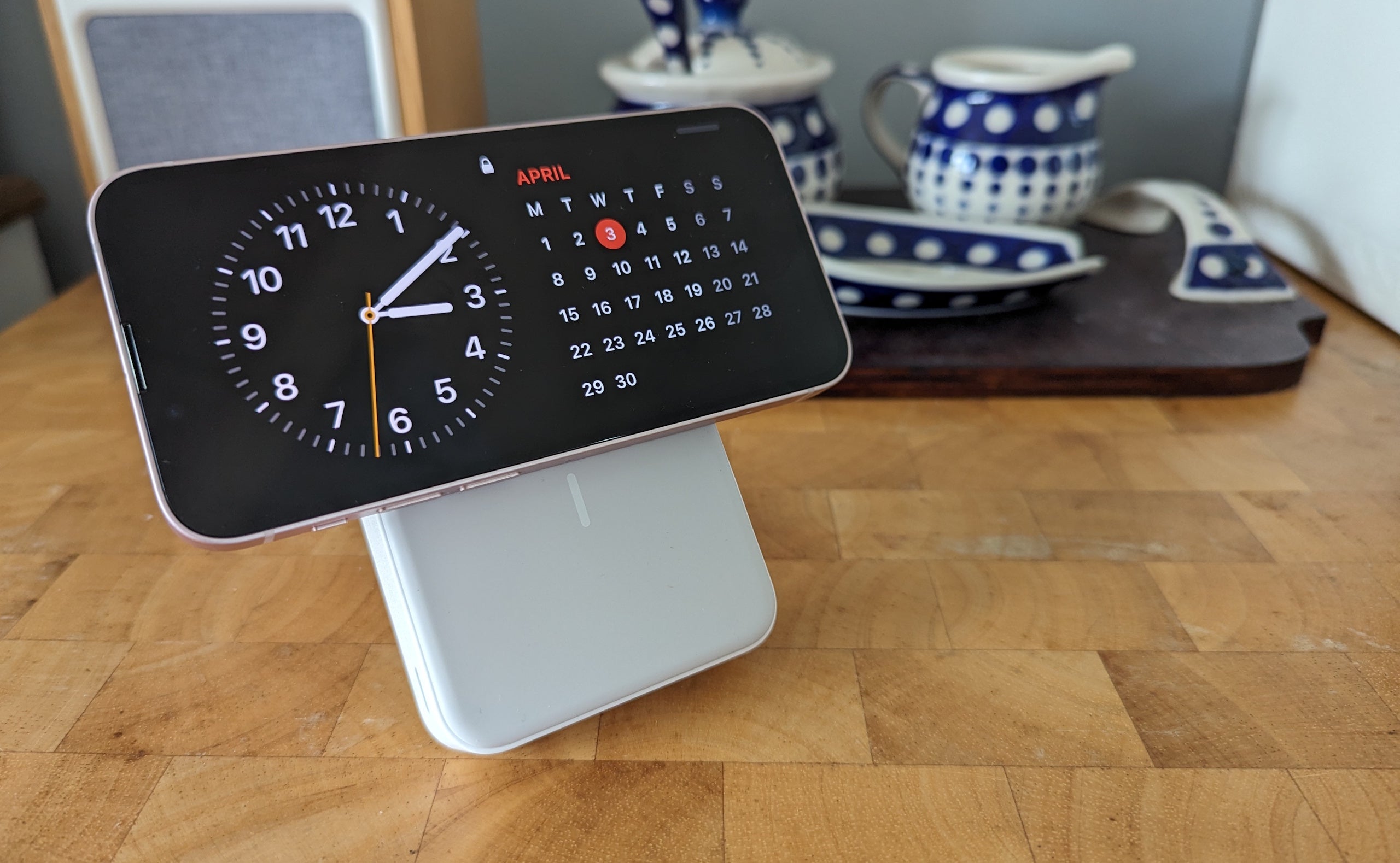 Anker MagGo Power Bank 10K на деревянной поверхности, заряжающий iPhone в горизонтальном положении